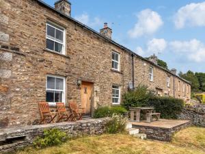 a stone house with two chairs and a table at Windy Ridge Low Row in Feetham