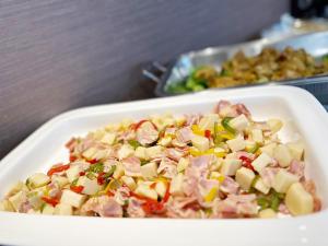 a white dish of food with meat and vegetables at Hotel Premium Green Plus in Sendai