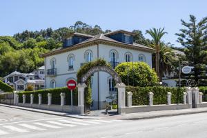 a white building with an arch on the side of a street at Casona Naviega in Navia