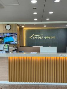 a lobby with a counter with a clock on the wall at 프레지던트 신라연수원 in Gyeongju