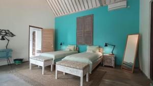 a room with two beds and a blue wall at Sun Moon Star Villas in Jarakan +88 photos