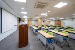 an empty classroom with desks and chairs and a podium at 프레지던트 신라연수원 in Gyeongju