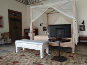 a bedroom with a bed with a television on a table at Sun Moon Star Villas in Jarakan