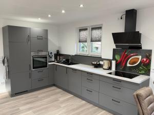 a kitchen with gray cabinets and a sink at Ferienwohnung Frankenruhe in Strullendorf