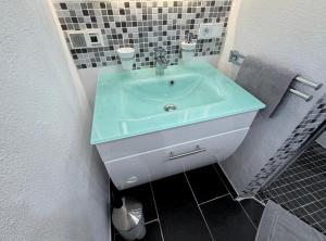 a bathroom with a sink with a blue counter top at Ferienwohnung Frankenruhe in Strullendorf +28 photos
