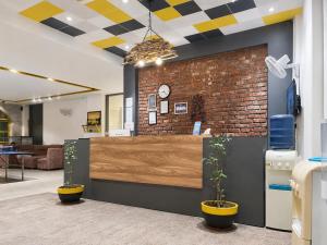 an office with a reception desk and a brick wall at Hotel Weekend Heights in Rishīkesh