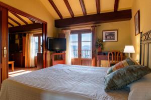 a bedroom with a large bed and a television at Hotel Rey Don Jaime in Morella +91 photos