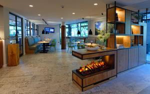 a lobby with a fireplace in the middle at Hotel am Kloster in Werne an der Lippe