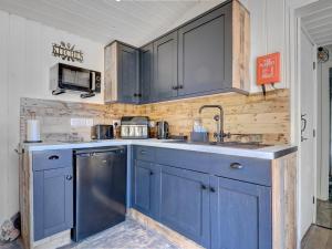 a kitchen with blue cabinets and a sink at Hoy Haven in Whitwell
