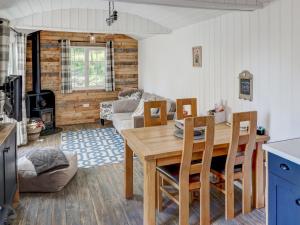 a kitchen and living room with a wooden table and chairs at Hoy Haven in Whitwell