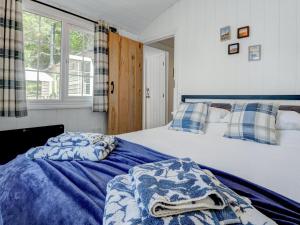 a bedroom with a bed with a blue comforter at Hoy Haven in Whitwell