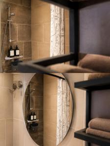 a bathroom with a round mirror and a shower at Wonenmeteenknipoog Groningerweg 23D in Peize