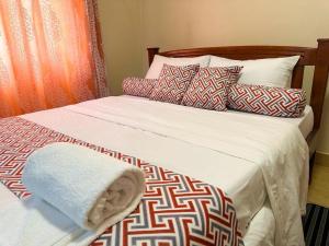a bed with pillows and a blanket on it at MakerereViewAirbnb in Kampala