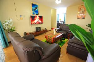 a living room with two couches and a tv at MakerereViewAirbnb in Kampala