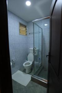 a bathroom with a toilet and a glass shower at MakerereViewAirbnb in Kampala