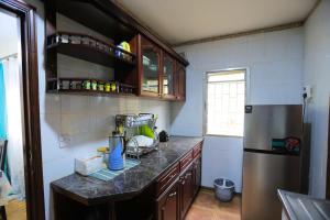 a kitchen with a counter top and a refrigerator at MakerereViewAirbnb in Kampala