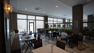 a restaurant with tables and chairs and windows at Remida Managed By Dedeman in İntepe