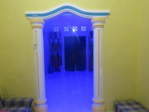 a room with a blue room with a pillar at Bahruksi HomeStay in Huta Baju