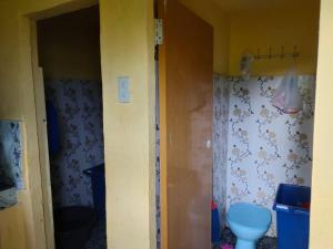 a small bathroom with a toilet in a room at Bahruksi HomeStay in Huta Baju