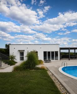 a white house with a swimming pool in a yard at Casa Cordis in Korduševci