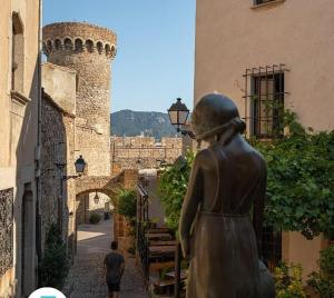 a statue of a woman looking at a castle at Parascheva St Jordi in Tossa de Mar