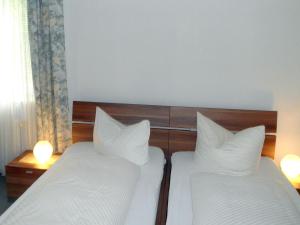 a bedroom with two beds with white sheets and pillows at Hotel Schneider in Bad Säckingen