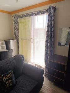 a living room with a couch and a window at Silent breeze home in Mombasa +5 photos