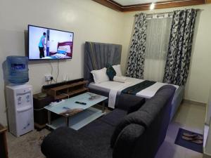 a living room with a couch and a tv at Silent breeze home in Mombasa