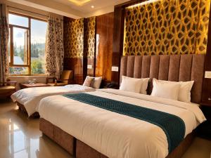 a hotel room with two beds and a window at Gulmarg Gul Sitara Resorts in Gulmarg