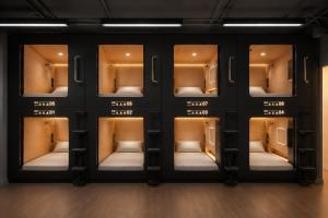 a room with a wall of shelves with seats in it at OWNLY CAPSULE Hotel in Bangkok