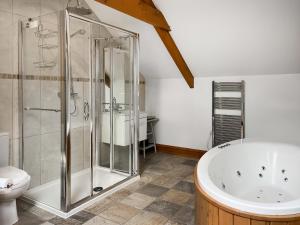 a bathroom with a shower and a tub and a toilet at Coach House in Holsworthy
