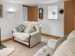 a living room with a couch and a chair at Coach House in Holsworthy