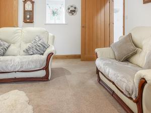a living room with two chairs and a couch at Coach House in Holsworthy +10 photos