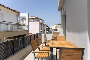 a row of wooden tables and chairs on a balcony at Baja Suites in Kalamata