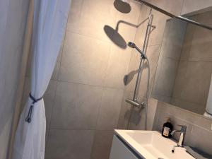 a bathroom with a shower curtain and a sink at Modern private Rooms with attached Bathroom & Free Parking in Bruges