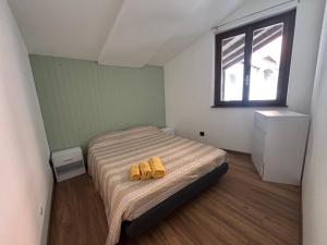 a bedroom with two yellow slippers on a bed at Sotto il castello in Borno