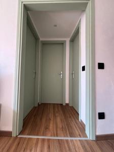 an empty hallway with two doors and wood floors at Sotto il castello in Borno