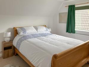 a bed in a bedroom with a green curtain at Mo Dhachaidh in Gairloch