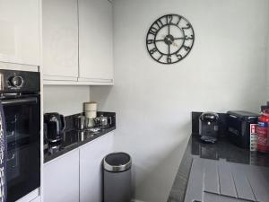 a kitchen with a clock on the wall at Mo Dhachaidh in Gairloch +8 photos