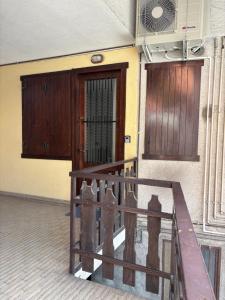 a building with a wooden door and a railing at Sotto il castello in Borno