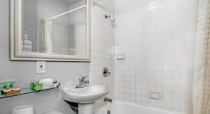 a white bathroom with a sink and a mirror at The Monarch Hotel in San Francisco +100 photos
