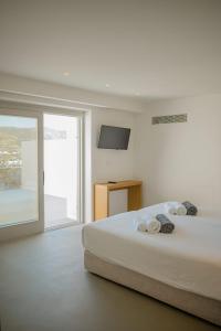 a white bedroom with a bed with towels on it at Amarelo Suites in Klouvas +103 photos