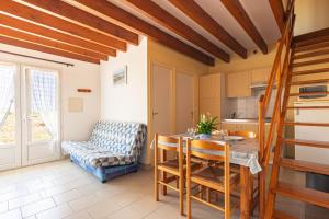 a kitchen and dining room with a table and a couch at Duplex N°6 - Résidence Balnéaire in Le Port-des-Barques