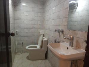 a bathroom with a white toilet and a sink at Grand Imperial Hotel in Chittagong