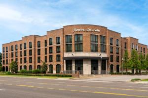 a large brick building on a street with a road at Hampton Inn & Suites Memphis Germantown in Memphis