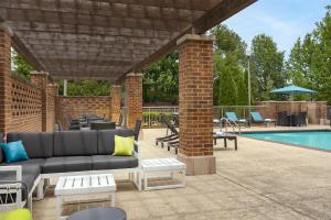 a patio with a couch and chairs next to a pool at Hampton Inn & Suites Memphis Germantown in Memphis
