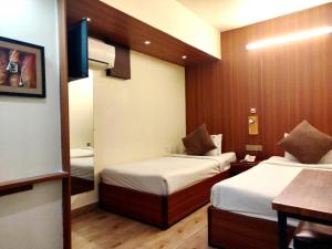 a hotel room with two beds and a table at Grand Imperial Hotel in Chittagong