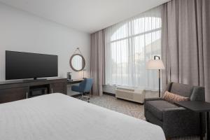 a hotel room with a bed and a television at Hampton Inn & Suites Memphis Germantown in Memphis