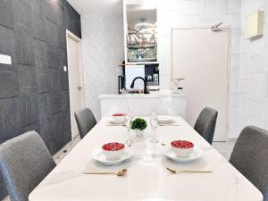 a dining room with a white table and chairs at 2BR Infinity Pool Condo Near Jonker 5Pax in Malacca
