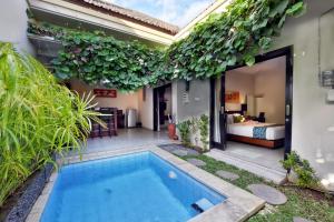 a villa with a swimming pool in a yard at Bali Corail Villas in Kerobokan